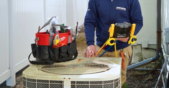 Townsend technician checking heat pump unit
