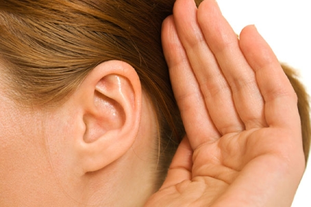 A close-up of a person’s ear and hand