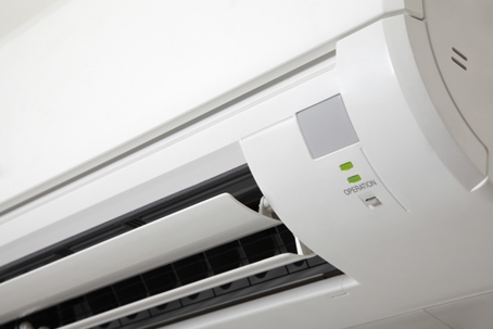 A close-up of a white, wall-mounted air conditioner