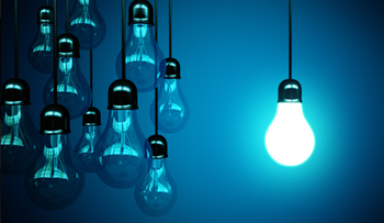 A blue toned image of lightbulbs, with most unlit, and one bright white, suggesting idea generation.