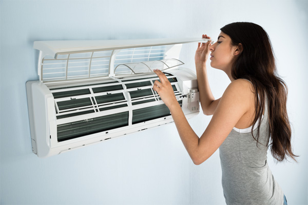 woman cleaning ductless mini-split filter