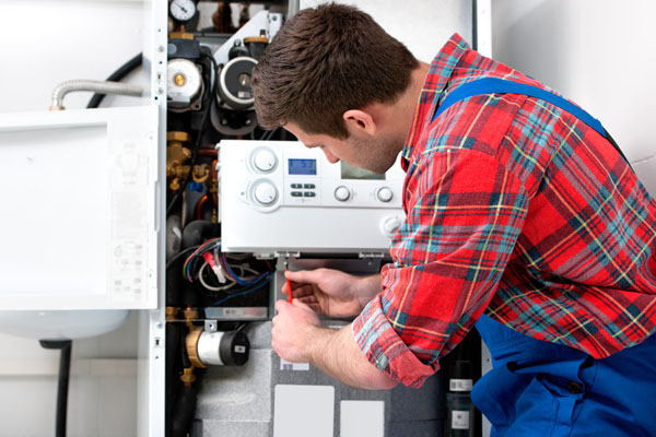 image of a boiler technician servicing a residential boiler
