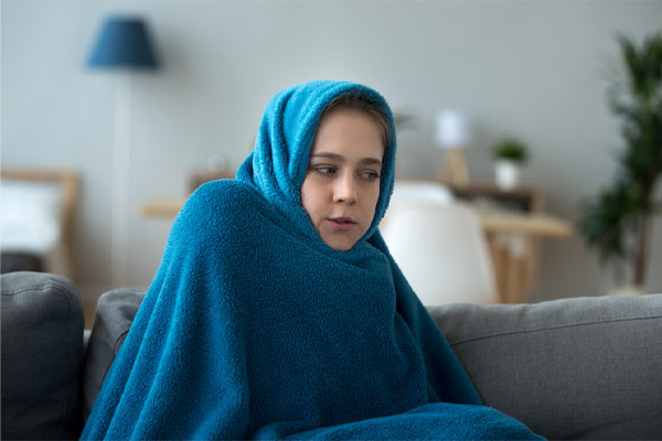 image of girl with blanket due to furnace short cycling