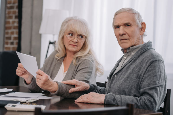 image of a couple paying high energy bills due to leaky ductwork