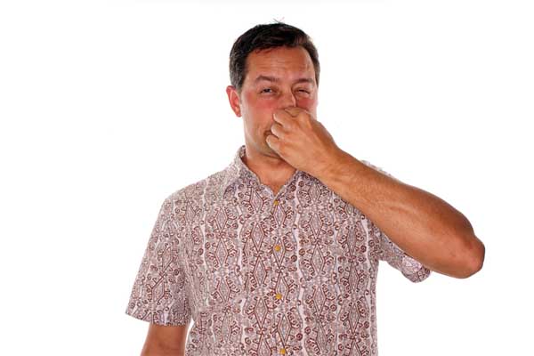 man plugging nose due to smelly air conditioner