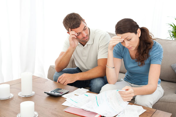 couple looking at energy costs and high energy cost of air conditioning