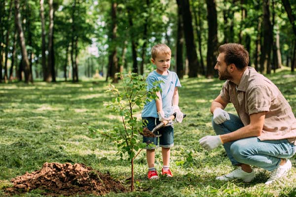 family planting trees to help with net zero emissions