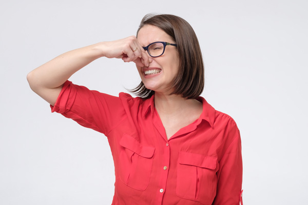 woman plugging nose due to smelly air conditioner