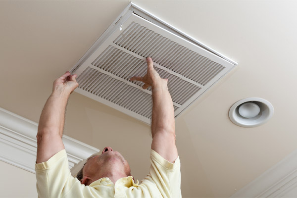image of a man replacing his home air filter