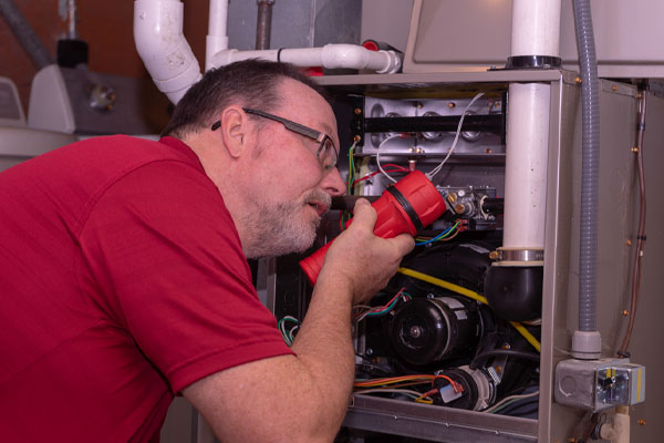 image of an hvac contractor repairing an overheating furnace