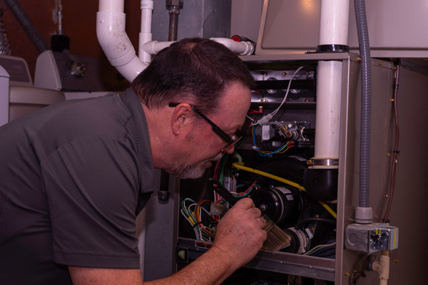 image of an hvac contractor performing furnace repair in a home