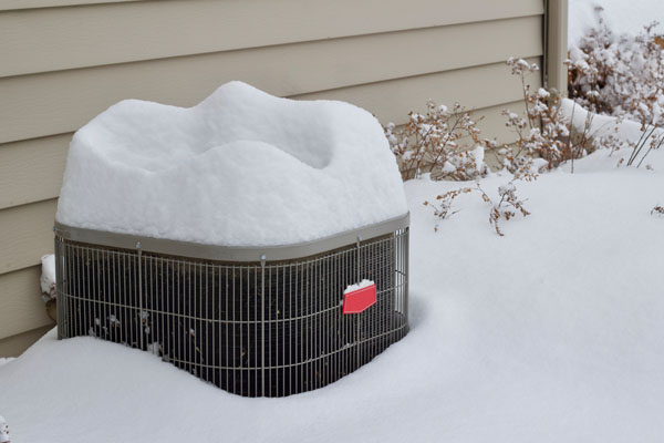 image of snow-covered heat pump in winter