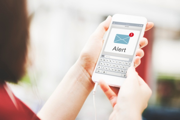 woman looking at phone with alert notification