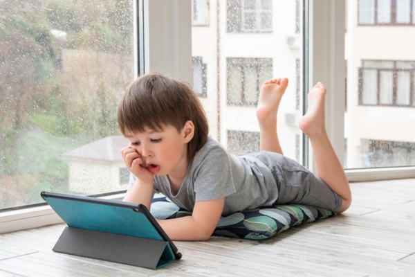 young boy watching on tablet while raining depicting stable internet despite generator switch